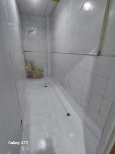 a bathroom with a toilet and a tiled floor at My Guest House She 