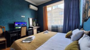 Habitación de hotel con cama y TV en Hotel Antalia en Tiflis