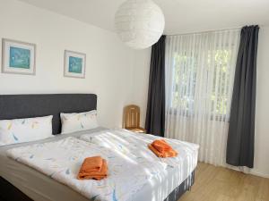 una camera da letto con un letto e asciugamani arancioni di Casa Mika a Costanza