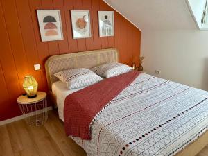 um quarto com uma cama grande e paredes cor-de-laranja em Douce Agathe - Duo-Groupe, Chaleureux, Tram 200m, Centre 10min em Estrasburgo