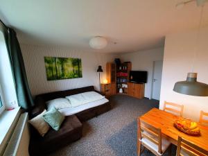 a living room with a couch and a table at radfreundliches Wohlfühl-Apartment mit Terrasse und Parkplatz - FeWo Woody in Schwerin