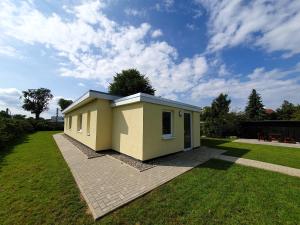 a small house in a yard with a green lawn at radfreundliches Wohlfühl-Apartment mit Terrasse und Parkplatz - FeWo Woody in Schwerin