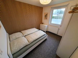 a small bedroom with a bed and a window at radfreundliches Wohlfühl-Apartment mit Terrasse und Parkplatz - FeWo Woody in Schwerin