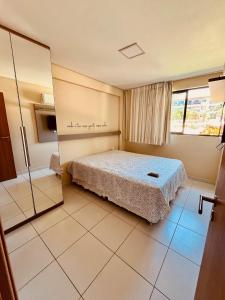 a bedroom with a bed and a mirror at Ecolife Térreo frente piscinas in Porto De Galinhas