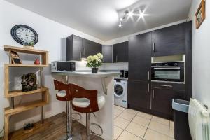 a kitchen with a table and a clock on the wall at Grande Île - Apartment near Disneyland Paris in Meaux