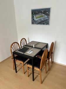 einen schwarzen Esstisch mit Stühlen und einem Bild in der Unterkunft Apartmán 3 + kk blízko centra in Hradec Králové