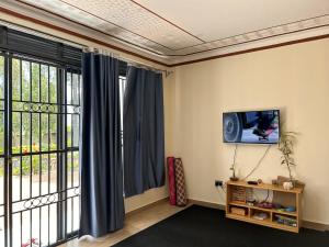sala de estar con TV y ventana grande en Ridgeway Victoria, en Wakiso