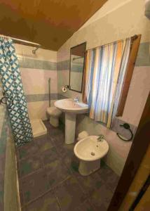 a bathroom with a sink and a toilet and a mirror at Villaggio Camping Calapineta in Siniscola