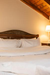 1 dormitorio con 1 cama con almohadas blancas en Guesthouse Lousios, en Dhimitsana