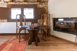 a dining room with two chairs and a table and a television at Guesthouse Lousios in Dimitsana