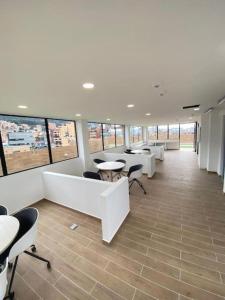 a large office with tables and chairs and windows at Apartaestudio Bacata 960 in Bogotá +33 photos