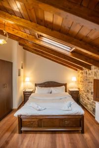 1 dormitorio con 1 cama grande y 2 mesitas de noche en Guesthouse Lousios, en Dhimitsana