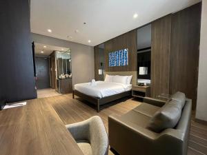 una camera da letto con un letto, un divano e un tavolo di Hotel A and A Quezon City powered by Cocotel a Manila