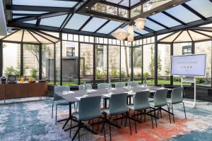 a conference room with a table and chairs and a screen at Hotel Villa Maillot in Paris