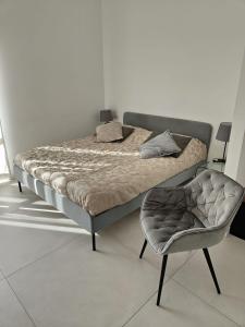 a bed and a chair in a room at Oasi al centro con parcheggio in Salerno