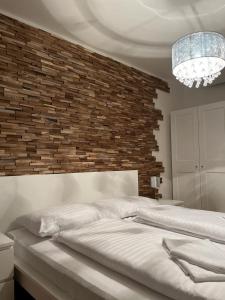 a bedroom with a large bed and a brick wall at Molo Lipno Apartment C301 Lipno Home in Lipno nad Vltavou
