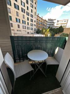 a table and chairs on a balcony with a table at Joli F2, 7 min de la gare in Cannes