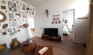 ein Wohnzimmer mit einem TV und ein Schlafzimmer in der Unterkunft Authentique échoppe bordelaise in Libourne