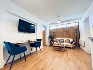 sala de estar con mesa y sofá en Private 2 Bed Guest House - Van Parking, M25 & A1 connections, en Potters Bar