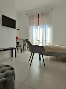 a white living room with a couch and a chair at Oasi al centro con parcheggio in Salerno