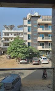 Blick auf einen Parkplatz mit Autos und ein Gebäude in der Unterkunft Hotel Shivaye Residency, Gurgaon 