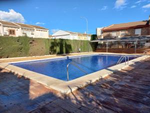 een groot zwembad in een tuin met een gebouw bij Appartement proche mer in Santiago de la Ribera