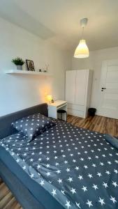 1 dormitorio con 1 cama grande y manta azul con estrellas blancas en Warszawa Centrum Pokoje, en Varsovia