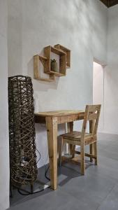 a wooden table and a chair in a room at Mano a Mano Eco Hostal in Las Peñitas