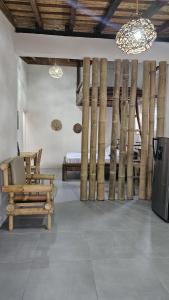 a room with a bench and a bed with bamboo poles at Mano a Mano Eco Hostal in Las Peñitas