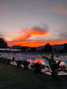 einen Sonnenuntergang über einem Pool in einem Park in der Unterkunft Studio 2 - LES SUITES DE ROBINSON - Résidence avec piscine en bord de Siagne, à Mandelieu-La-Napoule in Mandelieu-la-Napoule