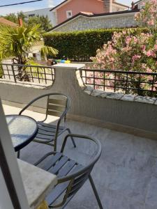 - une terrasse avec 2 chaises et une table dans l'établissement Apartments Pavlović, à Linardići