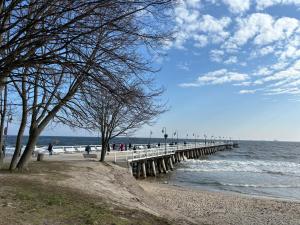 a pier with people walking on the beach at Guest Apartments Orłowo in Gdynia
