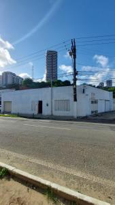 ein großes weißes Gebäude an der Straßenseite in der Unterkunft Pousada Bomfim in Maceió