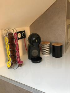 encimera de cocina con cafetera y 2 taburetes en Appartement Art moderne entre Disney et Paris, en Lagny 13 fotos más