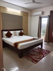 a bedroom with a large bed with a large window at ADI HOSPITALITY AND TOURS PRIVATE LIMITED in Bangalore