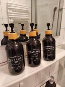 a group of bottles of soap on a shelf in a bathroom at * Wohlfühloase Köln I * in Cologne