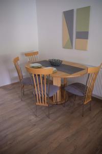 a dining room table with chairs and a wooden table at Kincses Vendégház in Senta