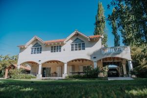 una gran casa blanca con un gran patio en Casa de Campo:4 Habitaciones con piscina y quincho, en Ciudad Lujan de Cuyo