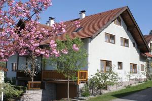 ein Haus mit einem blühenden Baum davor in der Unterkunft Pension Wenger in Kirchheim im Innkreis