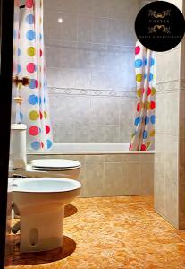 a bathroom with a toilet and a bath tub at Hotel y Restaurante Costas in Fortuna