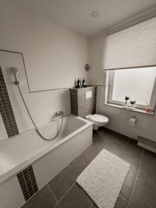 a bathroom with a bath tub and a toilet at Haus am Waldrand in Bad Hersfeld