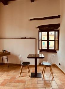 a table and chairs in a room with a window at LocAle Guest House in Pietralunga