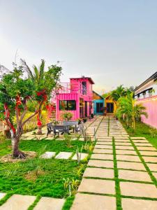 une maison rose avec une table de pique-nique dans une cour dans l'établissement Hồ Tràm Pink House, à Xuyên Mộc