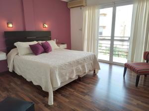 a bedroom with a large bed with purple pillows at Aparts Lio Nell in Colón