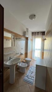 ein Badezimmer mit 2 WCs und einem Waschbecken in der Unterkunft Mon Amour in Santa Teresa Gallura