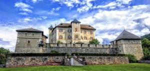 a large castle with two towers on top of a stone wall at B&B Vivi l'Attimo in Campodenno