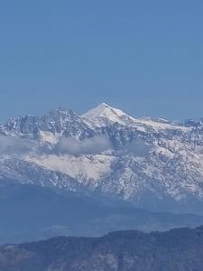 a snow covered mountain with a lake in front of it at Hotel Gogreen Kattike Pvt. Ltd. in Nagarkot