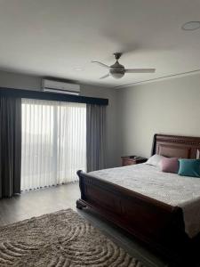 una camera con letto e ventilatore a soffitto di Alojamiento Kim House Orotina a Orotina