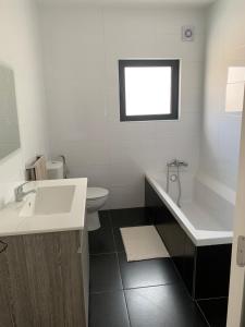 a bathroom with a sink and a tub and a toilet at Maison de vacances in Pombal