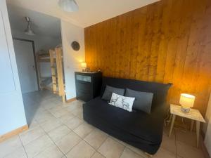 - un salon avec un canapé et un mur en bois dans l'établissement Petit Praz, à Praz-sur-Arly